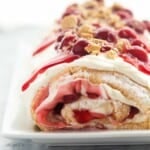 square image of cherry cheesecake angel food cake roll with cherry pie filling.