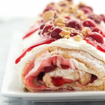 square image of cherry cheesecake angel food cake roll with cherry pie filling.