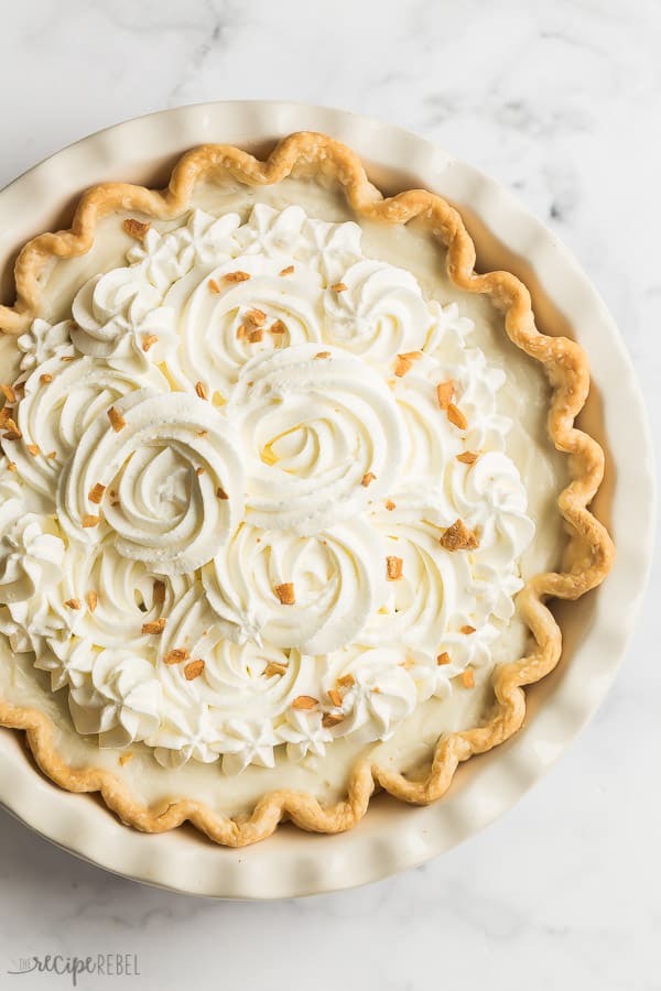 coconut cream pie overhead in white pie plate on marble background