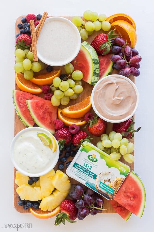 This Cream Cheese Fruit Dip is made 3 different ways and is a high protein, nutritious snack paired with fresh fruit! Try Chocolate Peanut Butter, Maple Cinnamon, or Lemon Lime. #fruit #dip #recipe #recipes #healthy cream cheese fruit dip platter with watermelon red grapes green grapes fresh strawberries raspberries pineapple and orange slices