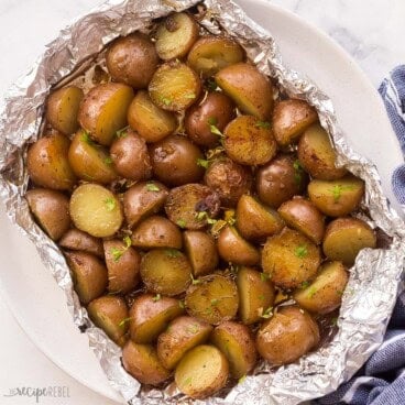 square image of halved baby potatoes grilled in foil pack.