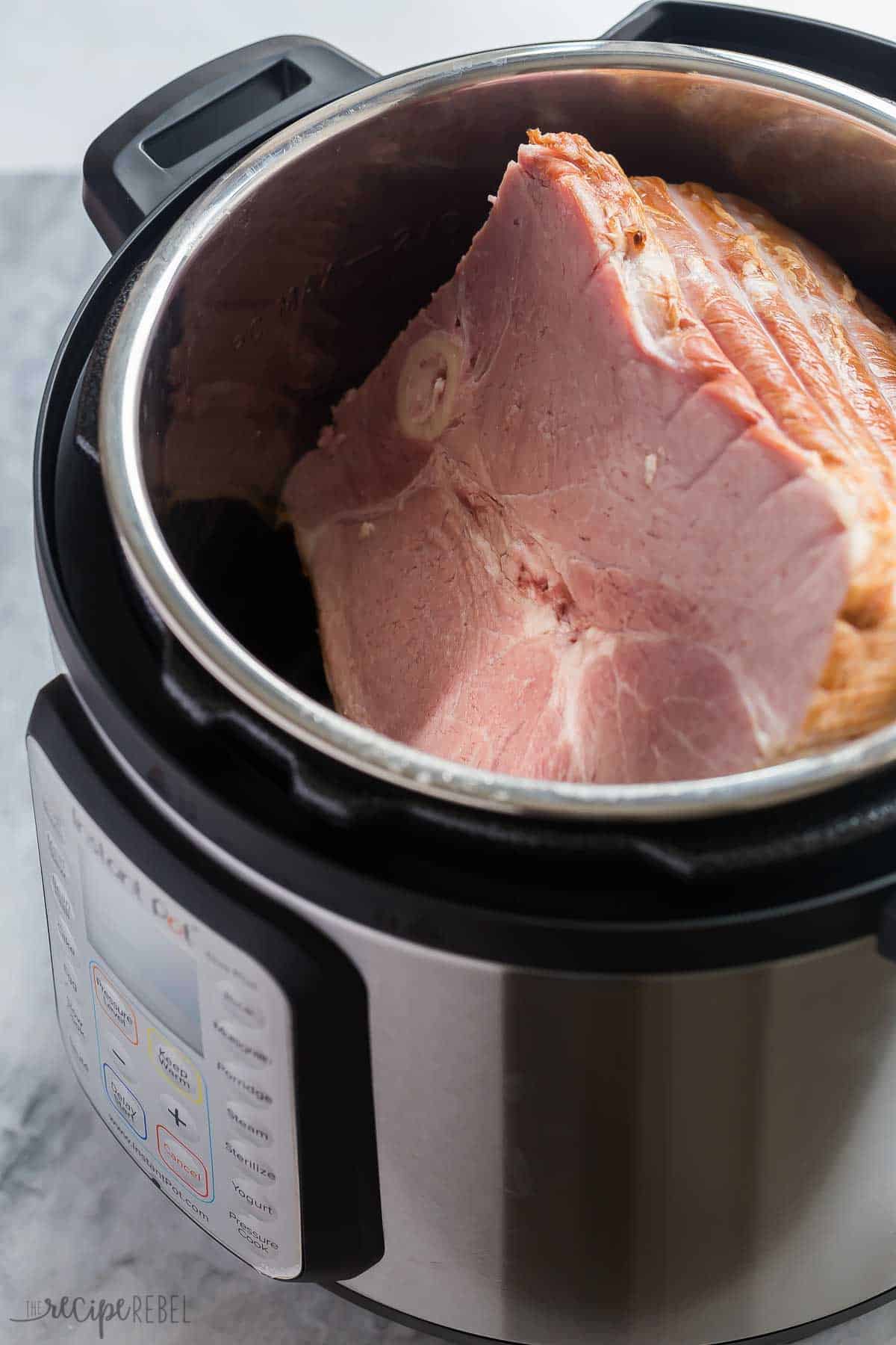 This Instant Pot Ham is SO juicy and couldn't be easier! Much faster than the oven, and drizzled with a simple, sweet pineapple glaze. #ham #instantpot #pressurecooker #easter #dinner #recipe instant pot ham whole in instant pot on grey background