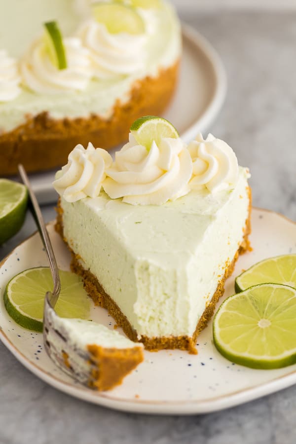 piece of no bake key lime cheesecake on plate with one bite missing