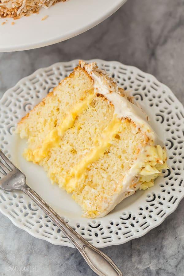 slice of pineapple coconut cake on white plate on grey marble background