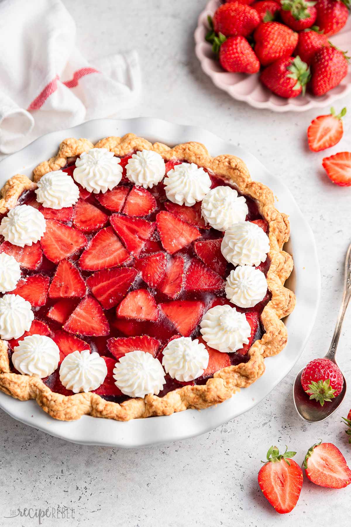 whole strawberry pie with whipped cream piped around the edges.