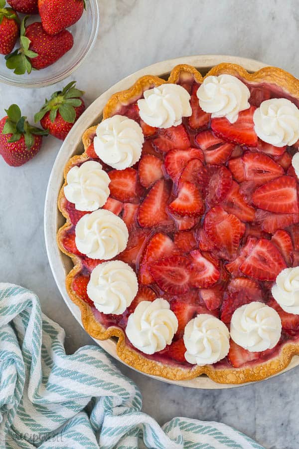 strawberry cream cheese pie whole overhead with whipped cream swirls on grey marble background