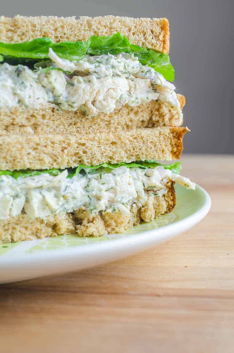 creamy chicken salad two sandwiches stacked on white plate