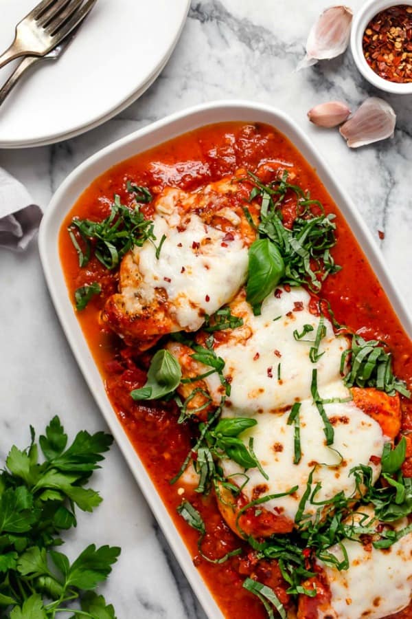 Instant Pot chicken Parmesan in casserole dish overhead on marble with tomato sauce and cheese on top
