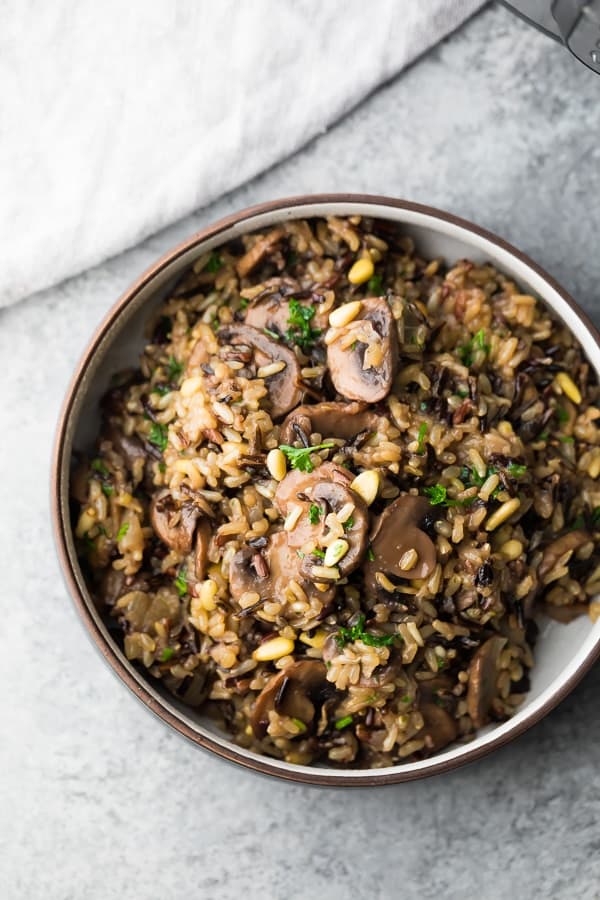 instant pot wild rice pilaf in white bowl with brown rim on grey background