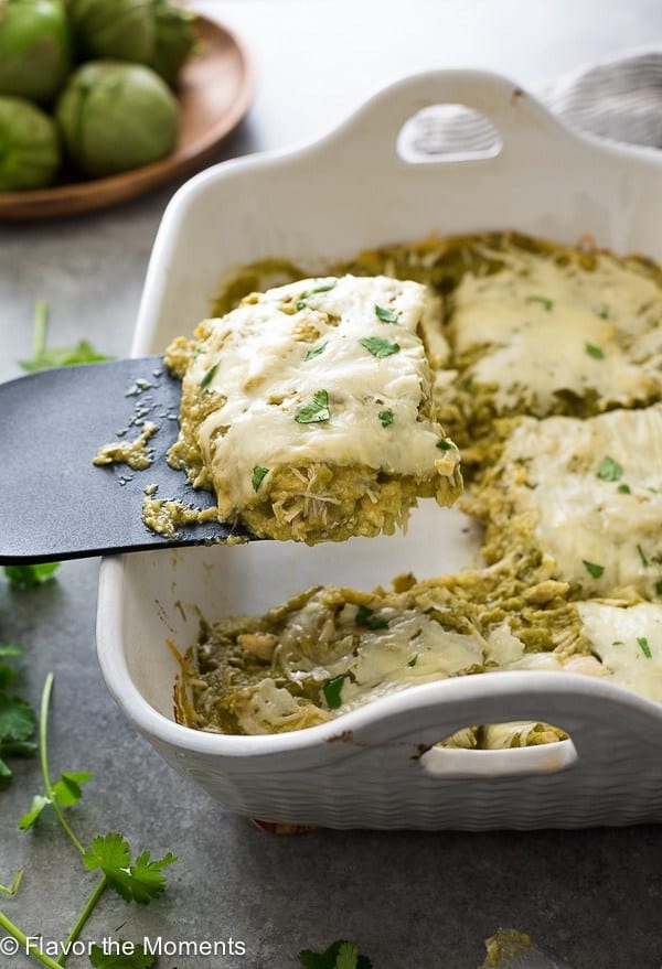 chicken verde enchilada bake with spatula scooping out a piece