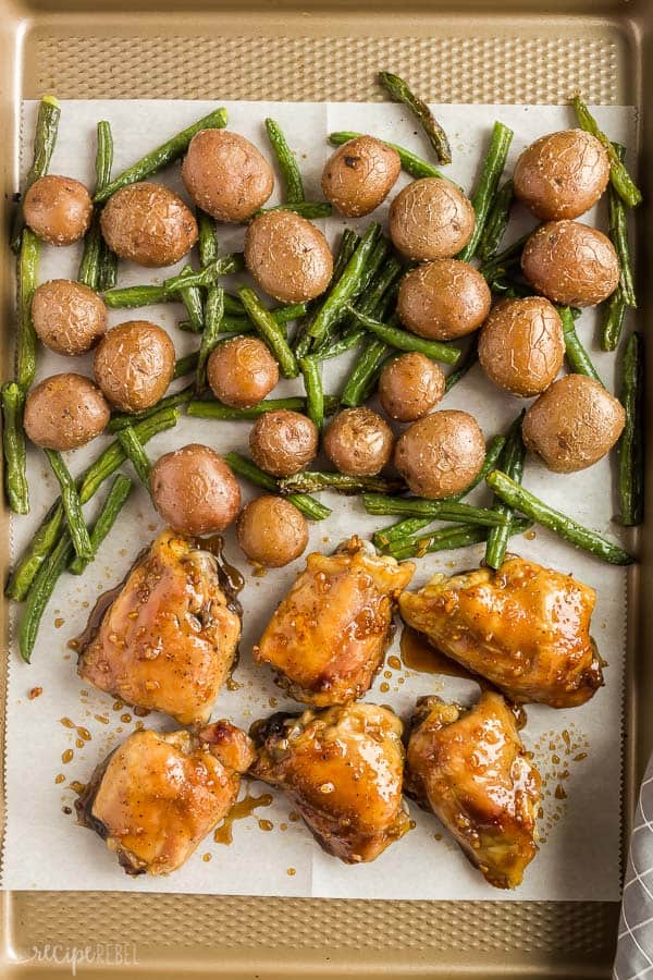 honey garlic chicken thighs sheet pan dinner on rimmed sheet pan with potatoes and green beans
