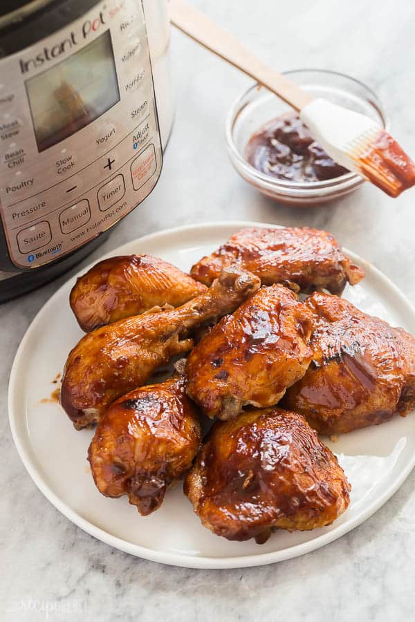 instant pot bbq chicken on white plate with pressure cooker in the background