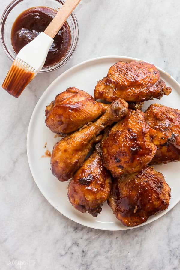 instant pot bbq chicken on white plate overhead on grey marble background with bbq sauce on the side