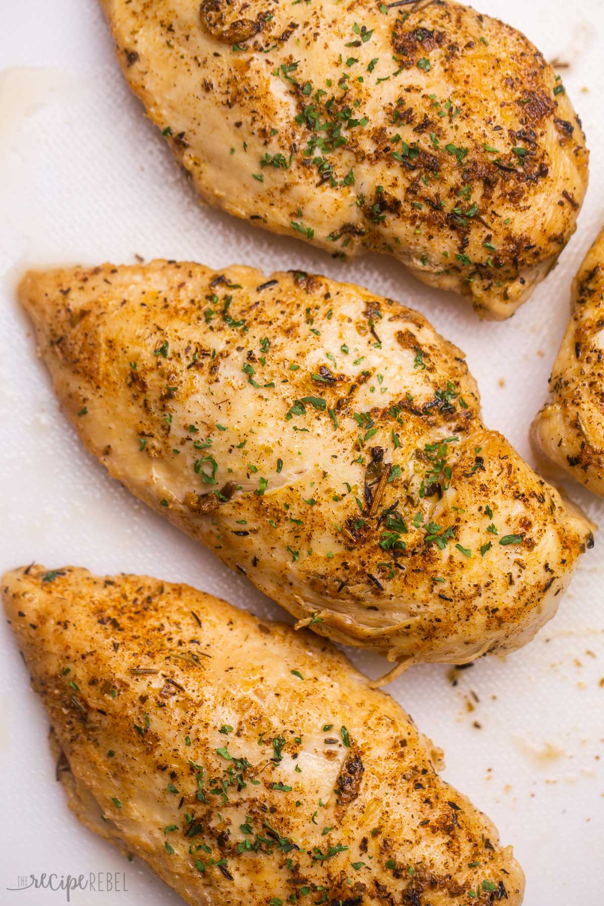 whole instant pot chicken breast on a white cutting board.