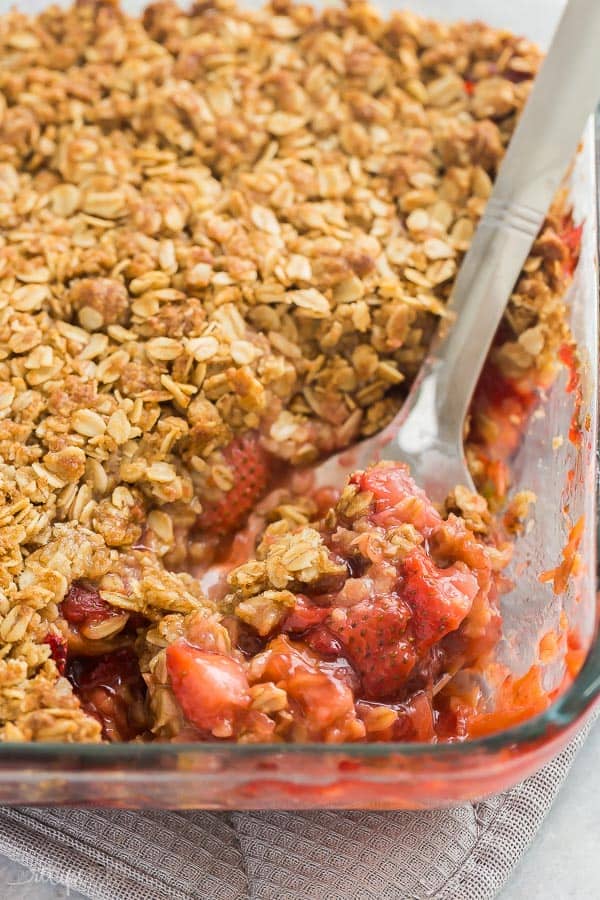 strawberry rhubarb crisp close up of scoop in glass baking dish