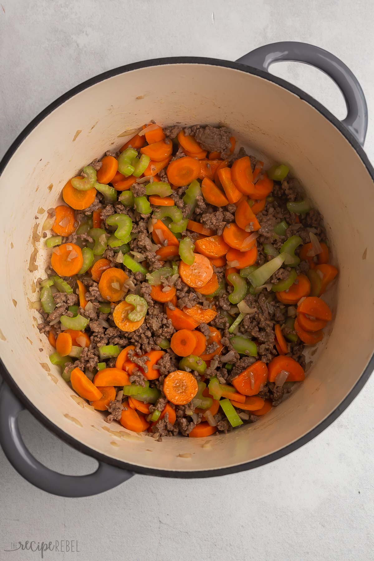 vegetables added to ground beef in dutch oven.