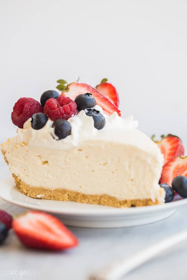 easy cheesecake recipe close up slice on white plate with berries