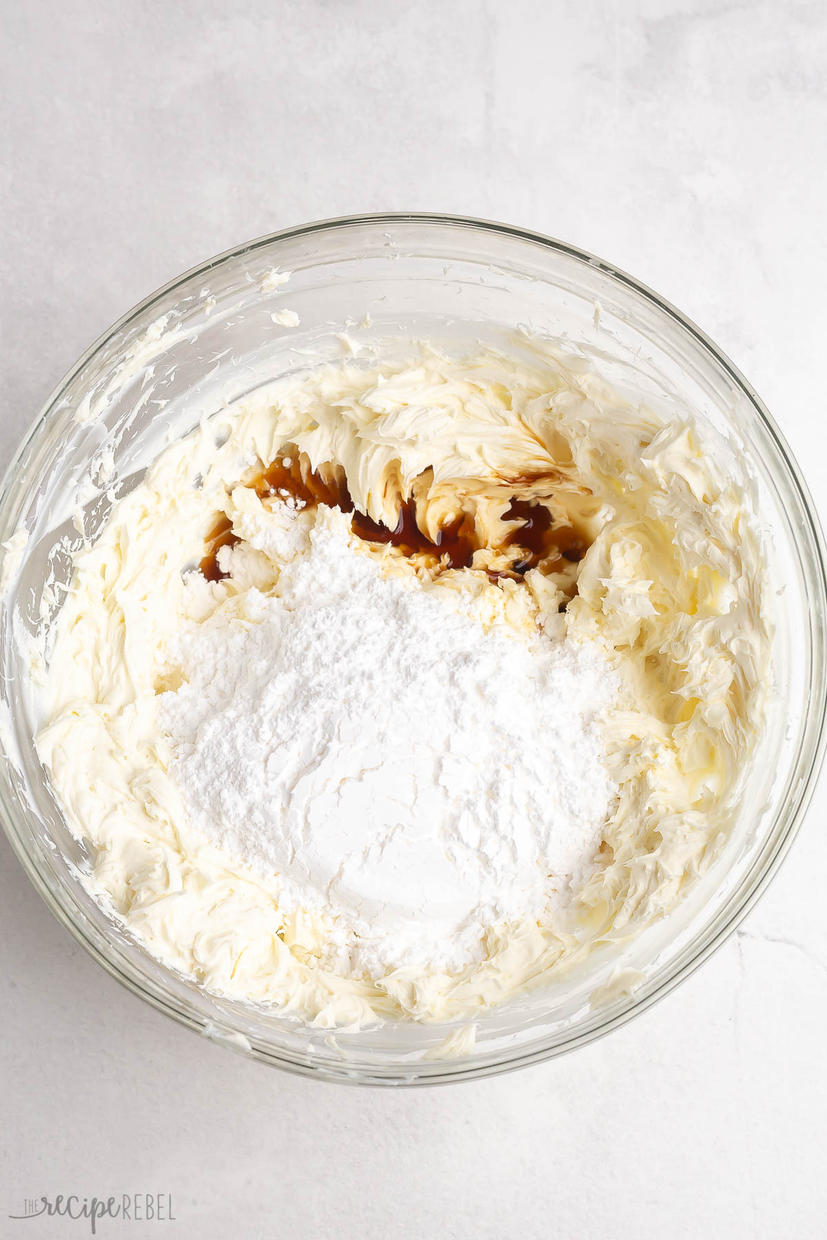 powdered sugar and vanilla added to cream cheese in bowl.