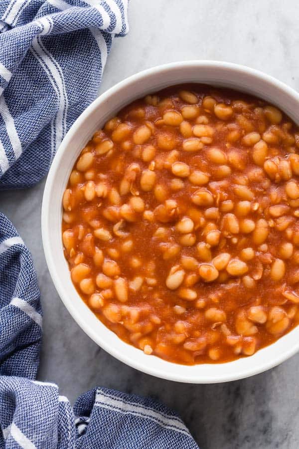 instant pot baked beans in bowl overhead on grey marble with blue towel on the side