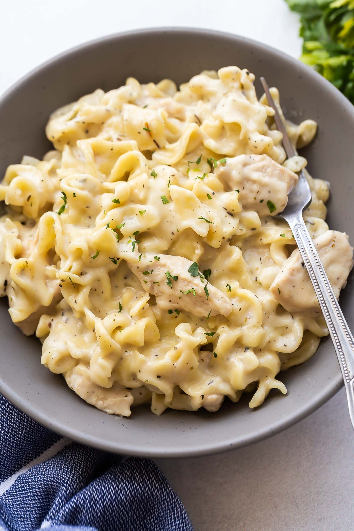 close up image of instant pot chicken and noodles on grey plate.