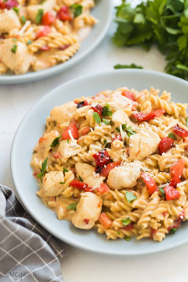 instant pot italian chicken pasta on plate with roasted red peppers and fresh parsley