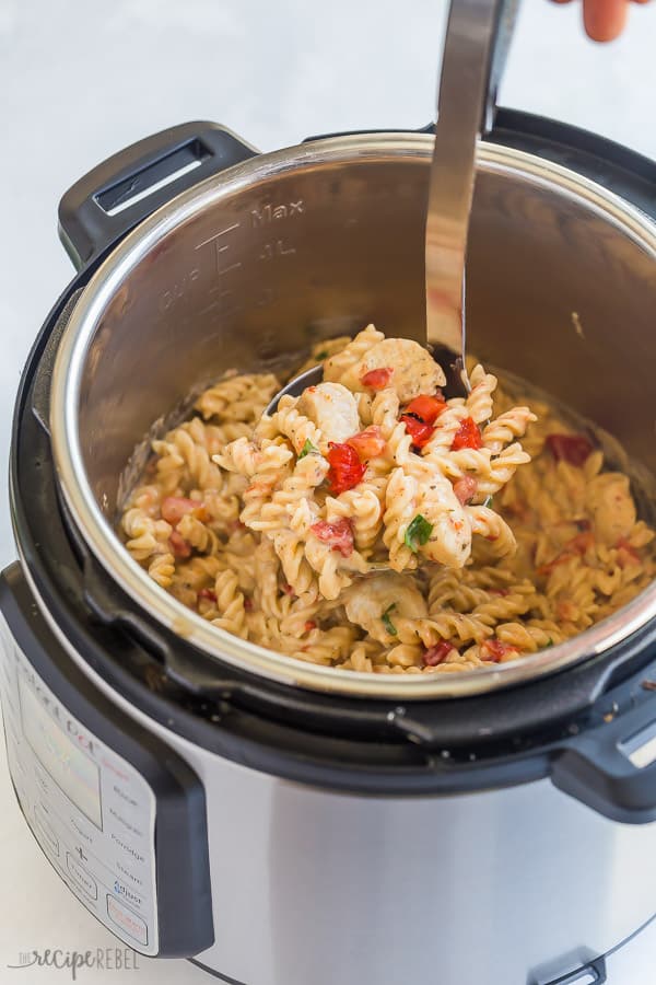 instant pot chicken pasta in pressure cooker with metal scoop pulling some out
