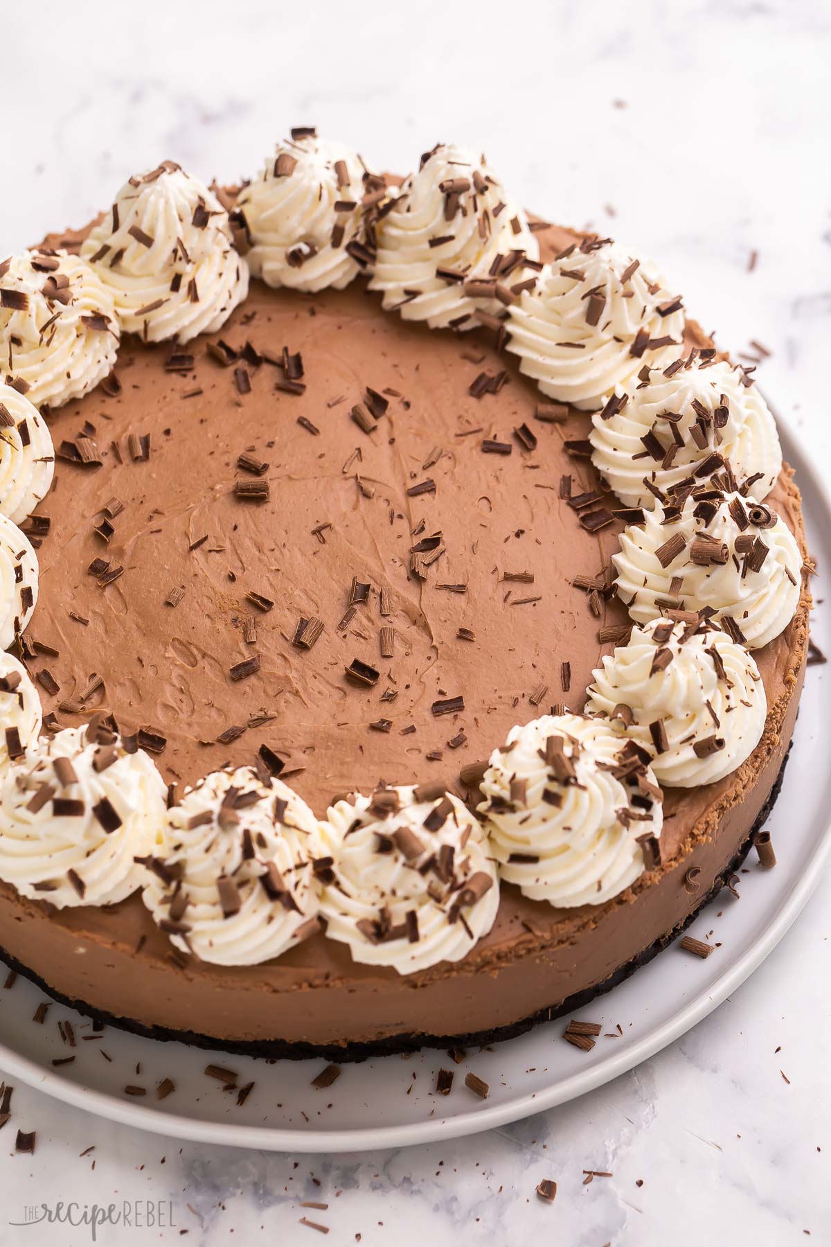 This No Bake Chocolate Cheesecake is smooth, creamy and comes together with just a few ingredients! Top it with caramel sauce, extra chocolate or fresh fruit and berries. #chocolate #cheesecake | chocolate cheesecake | cheesecake recipe | no bake recipes | no bake dessert | chocolate dessert no bake chocolate cheesecake with whipped cream and chocolate shavings.
