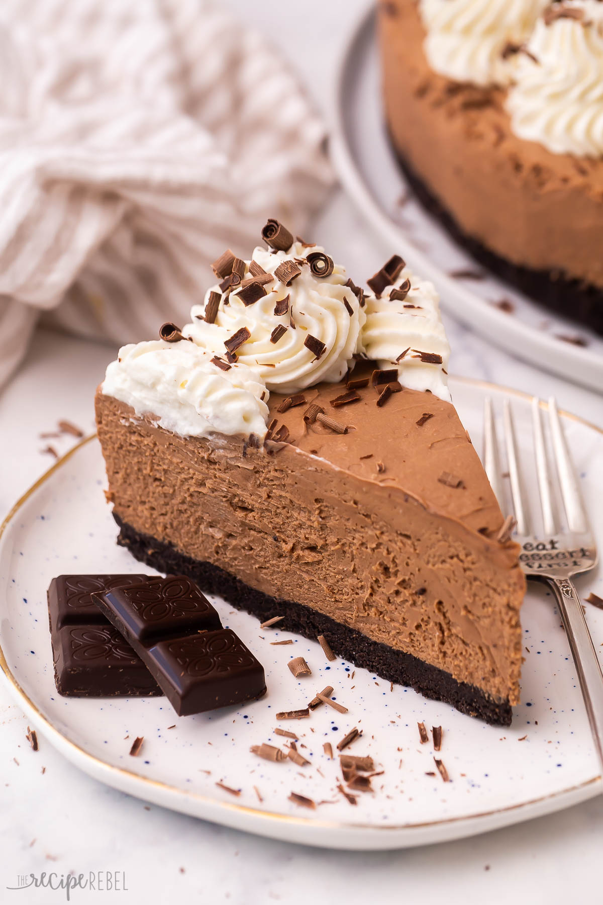 slice of chocolate cheesecake on a plate with chocolate shavings.