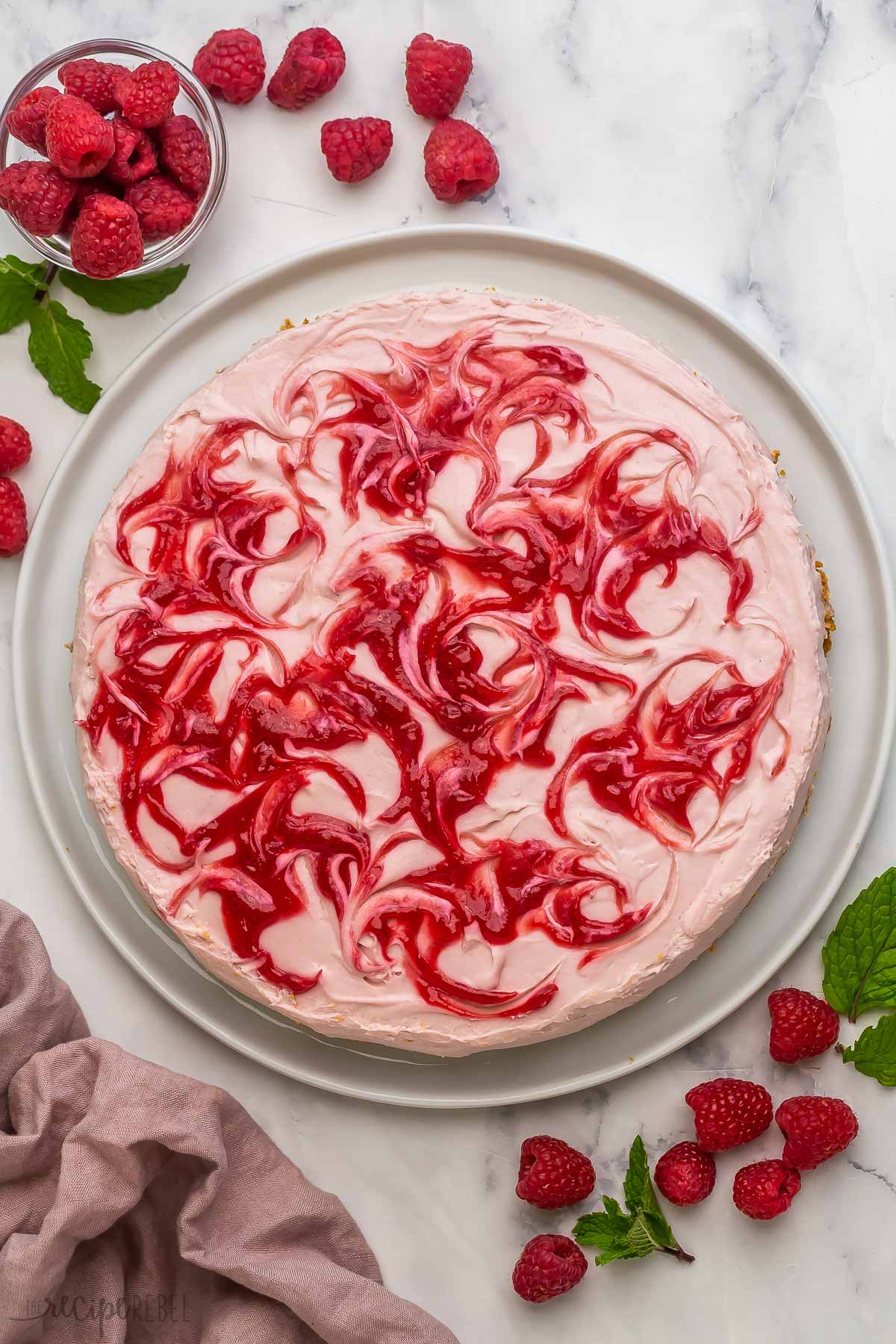 overhead image of no bake raspberry cheesecake with raspberry swirls.