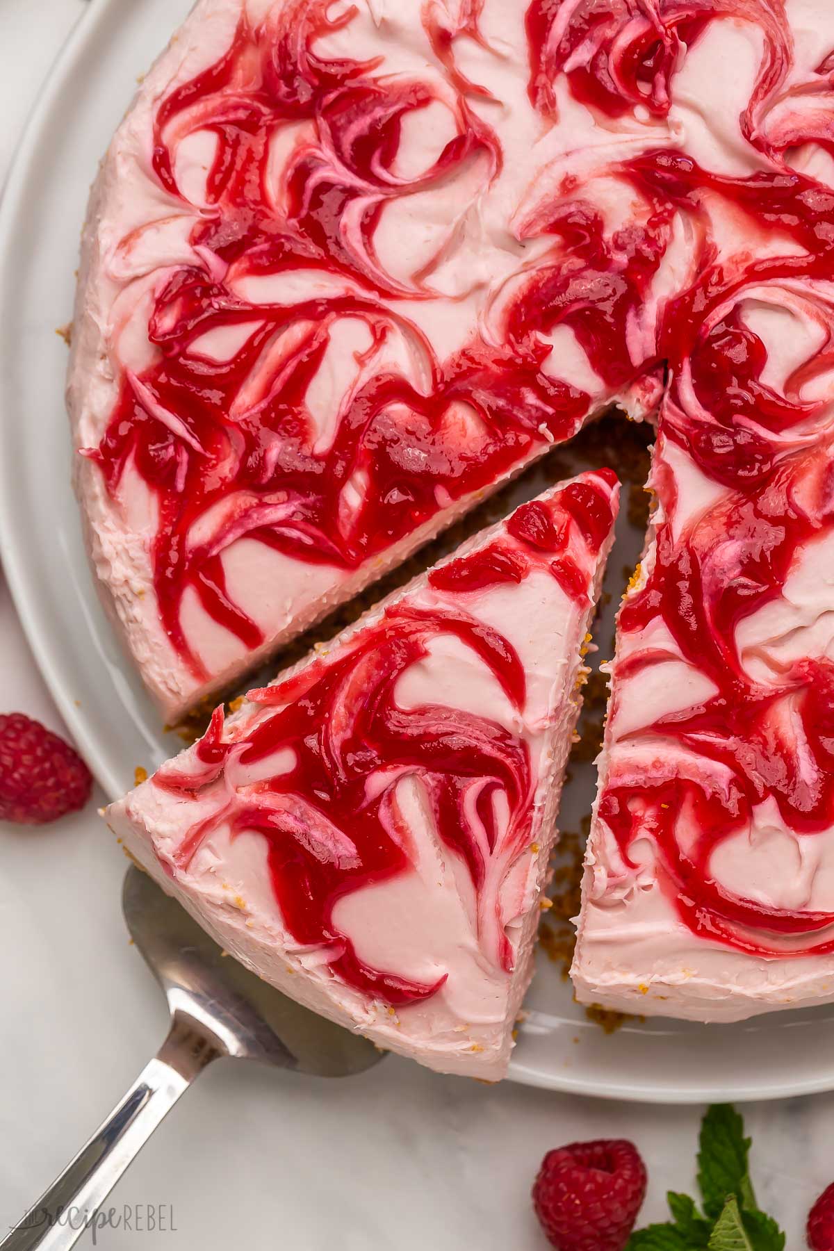 close up image of slice of raspberry cheesecake being pulled out.