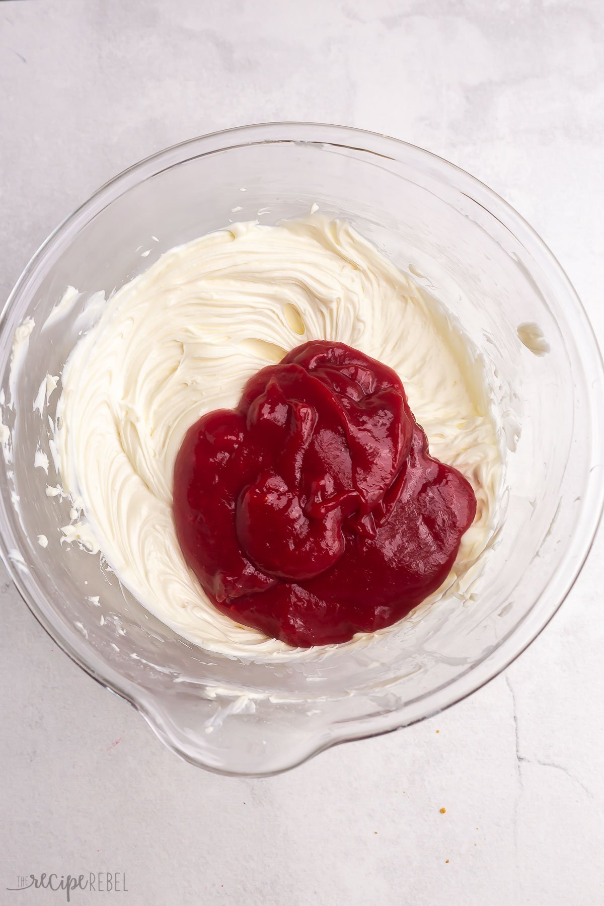 cooked raspberry puree with cream cheese in glass bowl.