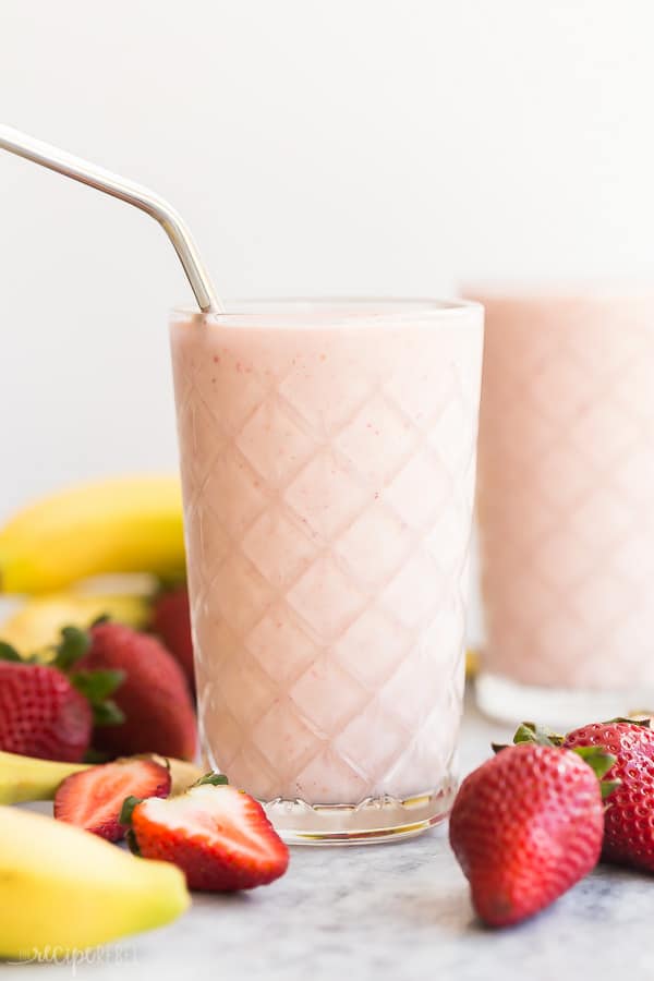 healthy strawberry smoothie with steel straw close up on white background