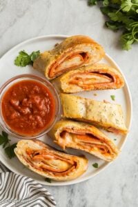 plate of sliced stromboli with pizza sauce
