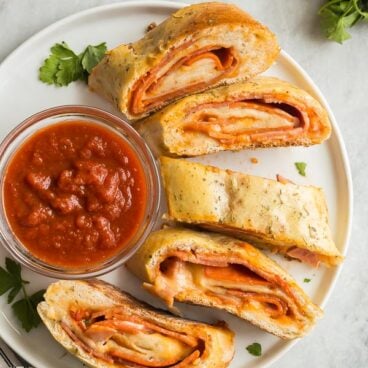 plate of sliced stromboli with pizza sauce