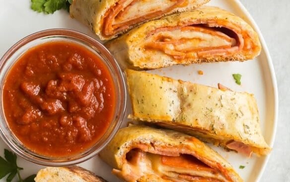 plate of sliced stromboli with pizza sauce