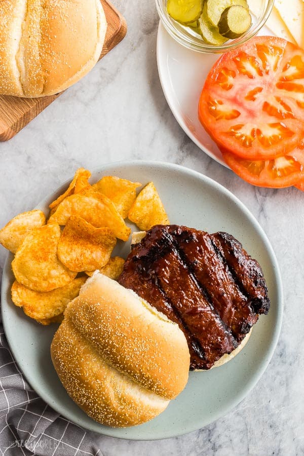 turkey burgers overhead on plate on bun with fresh tomatoes slices on the side