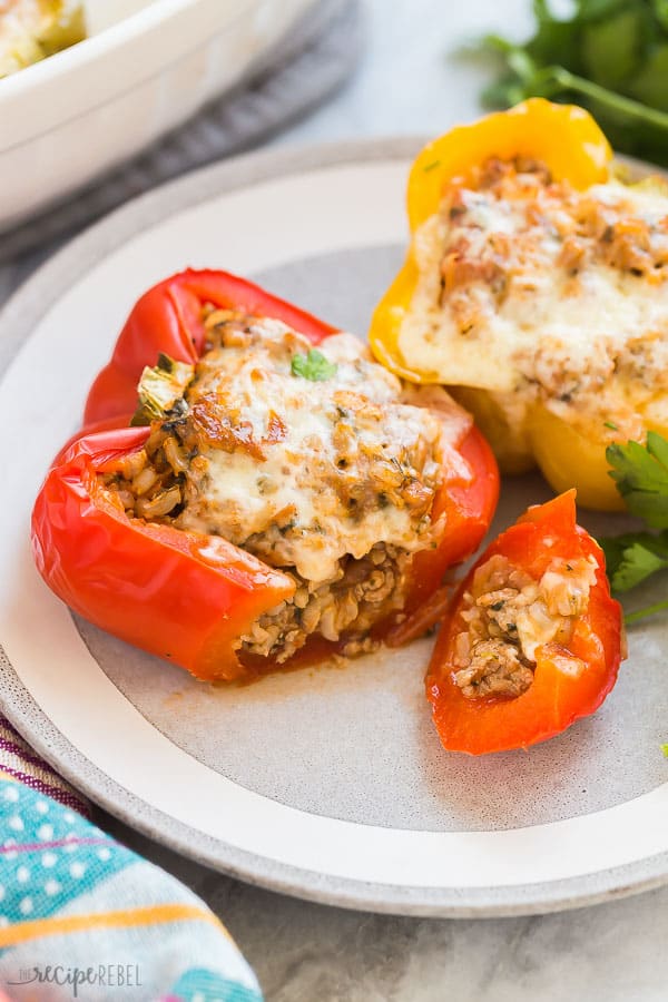 ground turkey stuffed peppers cut open on grey plate on marble background