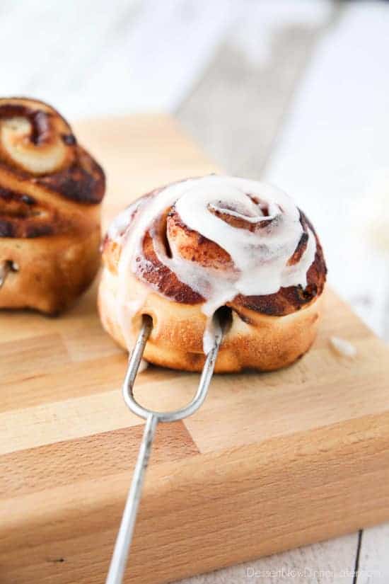 campfire cinnamon rolls on roasting stick with icing