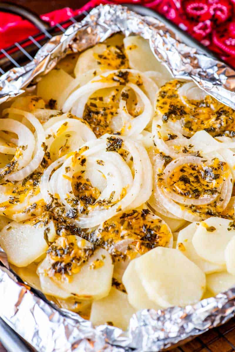 campfire potatoes with seasoning and onion slices in foil packet