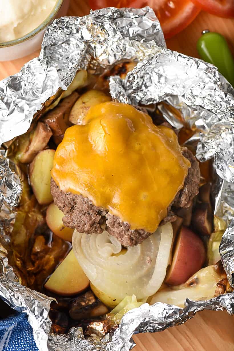 hobo hamburger foil packets with melted cheese slice on top