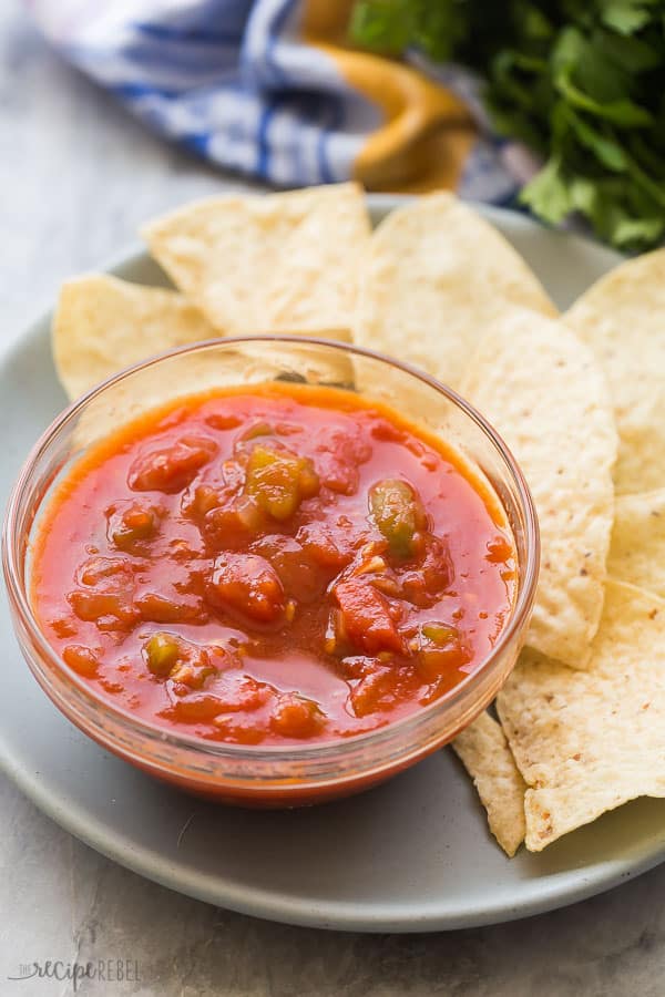 homemade salsa recipe in glass bowl close up with tortilla chips in the background