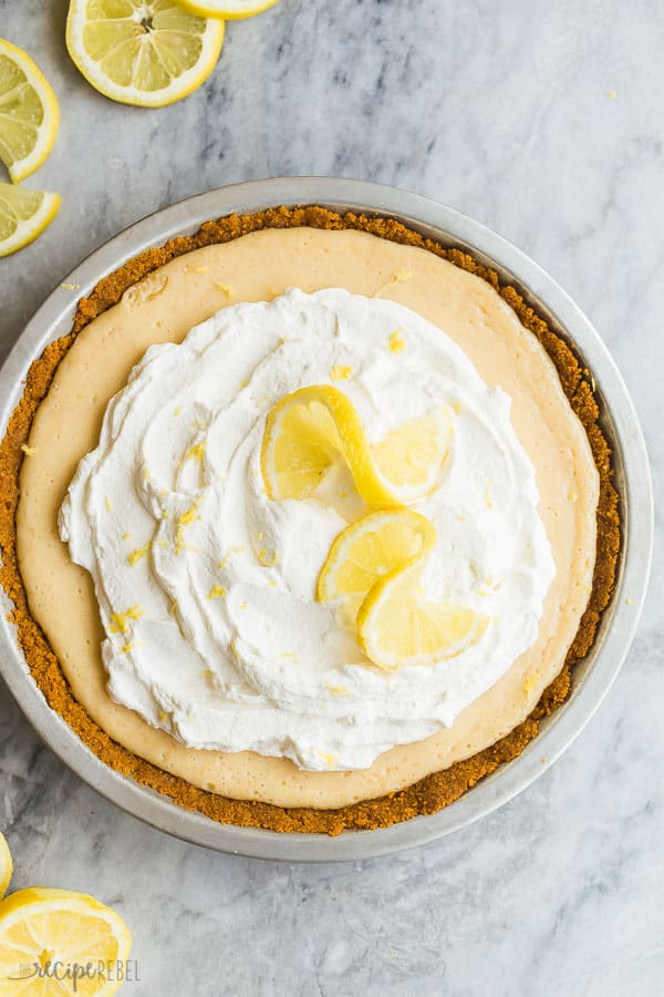 lemon icebox pie whole overhead with whipped cream and two lemon slices