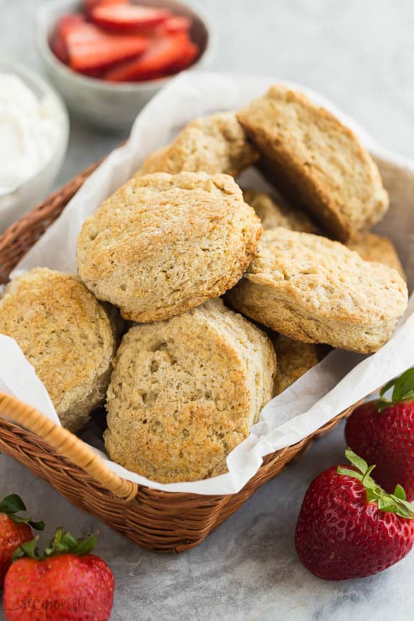 strawberry shortcake biscuits in a basket with fresh strawberries in the background