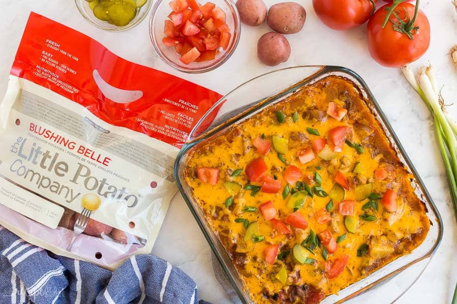 cheeseburger casserole overhead with bag of little potatoes and blue towel