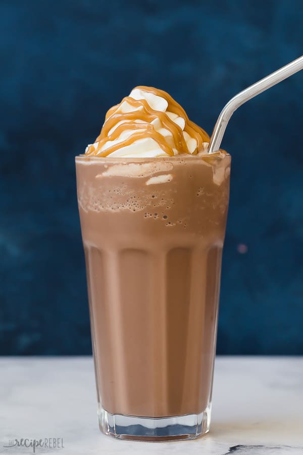 peanut butter frozen hot chocolate with peanut butter drizzle against a blue background