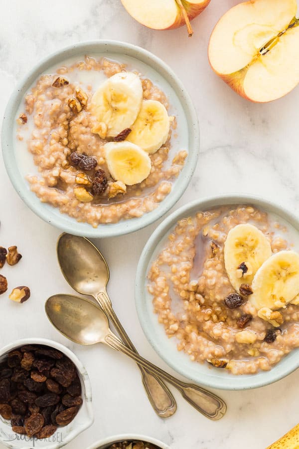 slow cooker oatmeal in bowls overhead with banana slices raisins and walnuts on top