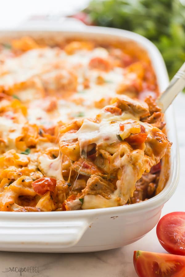 baked tortellini being scooped up close with a metal spoon