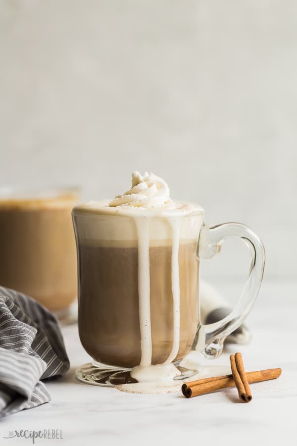 slow cooker pumpkin spice latte with whipped cream with foam running down the mug