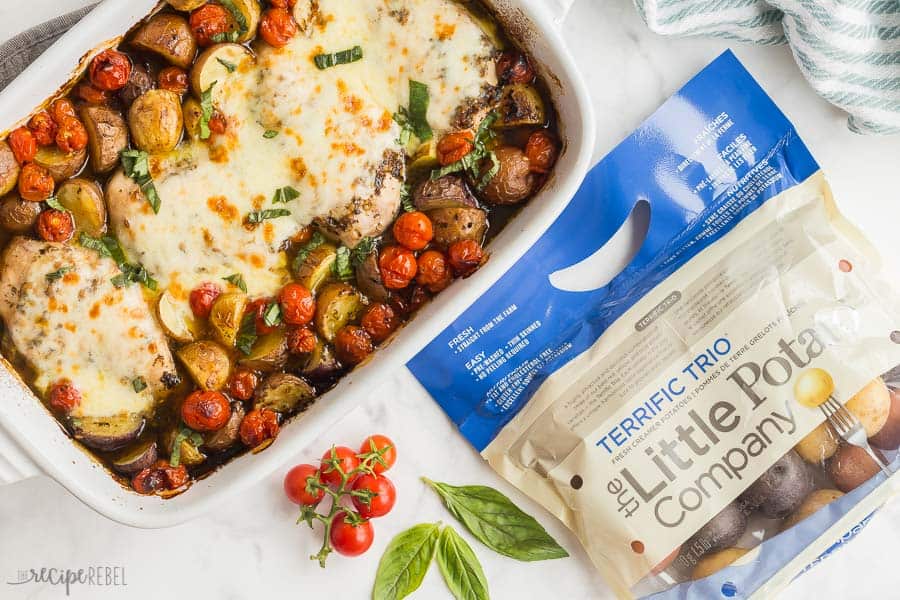 chicken caprese with potatoes overhead with bag of little potatoes on white marble background