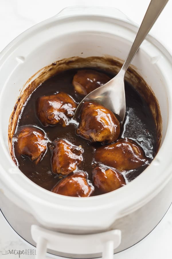 crockpot chicken thighs in slow cooker with thick balsamic glaze and metal spoon